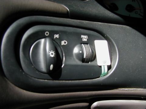 1997 Ford Taurus - Close-up of the headlight control knob and panel dimmer switch on a vehicle's dashboard.