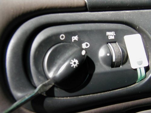close-up of car's headlight switch and panel dimmer knob