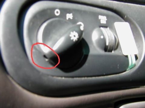 1997 Ford Taurus - Close-up of a vehicle's interior controls, showing the headlight switch and dimmer.