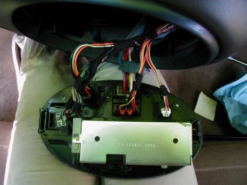 1997 Ford Taurus - Exposed wiring and electronic components are visible after removing the radio and instrument cluster from a vehicle's dashboard.
