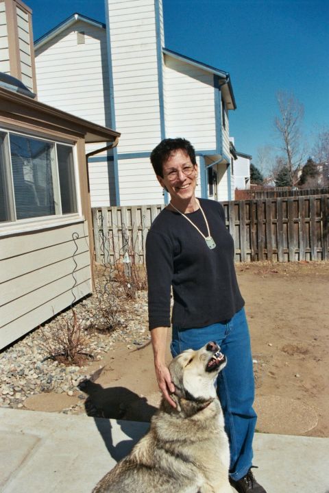 1993 Ford Bronco - A woman smiles while petting her dog in a suburban backyard on a sunny day.