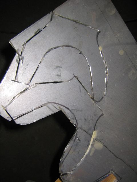 1978 Ford Bronco - A sheet of metal plate with a curved, sculptural shape plasma-cut or scribed into its surface, likely a fabricated bracket or arm component…