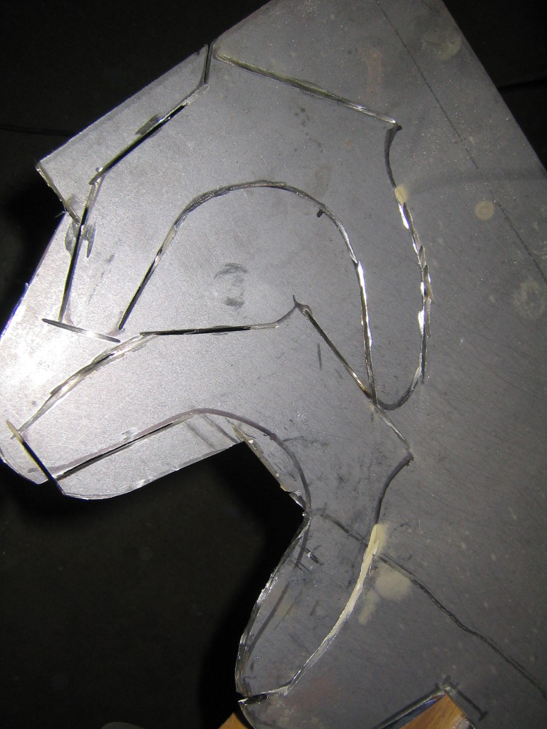 Bare steel plate with curved cut/scribed profile for a fabricated part