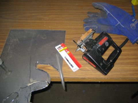 1978 Ford Bronco - A workbench scene showing a black jigsaw, a package of SKIL jigsaw blades, blue leather welding gloves, and a piece of cut sheet metal with…