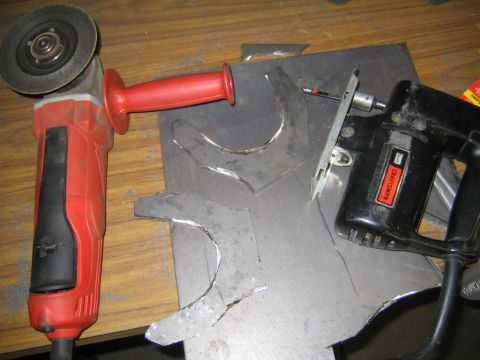 1978 Ford Bronco - A workbench scene showing metal fabrication in progress: a red Milwaukee angle grinder, a black Craftsman jigsaw, and sheet metal pieces wi…