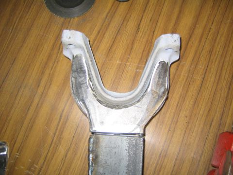 1978 Ford Bronco - Close-up of a fabricated metal Y-shaped yoke or suspension bracket with fresh weld beads at the fork base and along a tubular arm, resting…