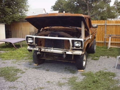 1988 Ford Bronco - This rusty brown SUV, likely from the early 1980s, is shown with its hood open in a yard.