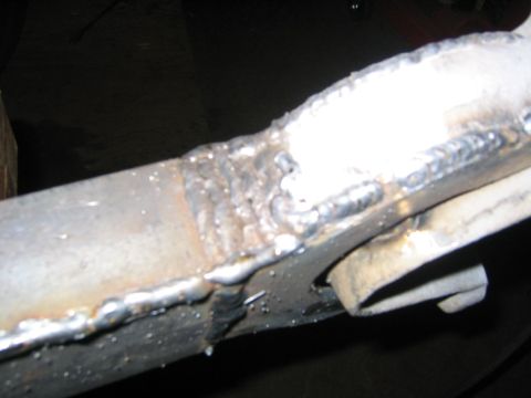 1978 Ford Bronco - Close-up of a freshly welded joint on a metal tubular suspension arm or axle component, showing a bright silver weld bead connecting two st…