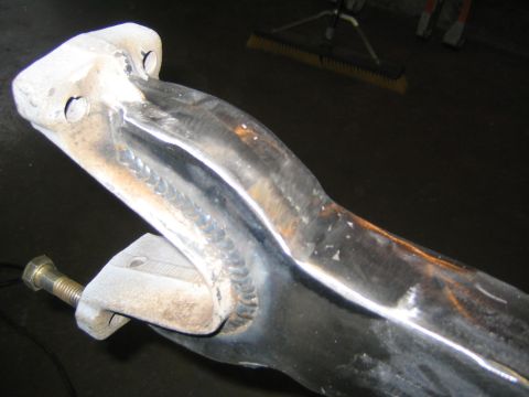 1978 Ford Bronco - Close-up of a polished aluminum suspension arm or axle bracket with fresh TIG weld beads joining cast mounting tabs to the tubular section.…