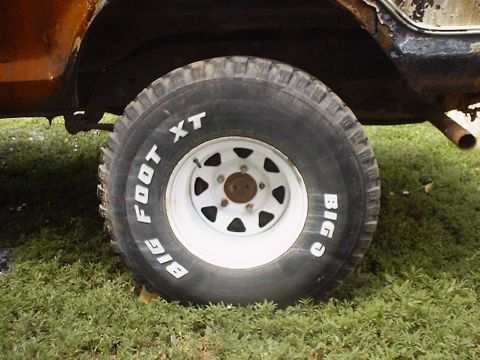 1988 Ford Bronco - Close-up of a tire with 'BIG FOOT XT' text, part of a vehicle.