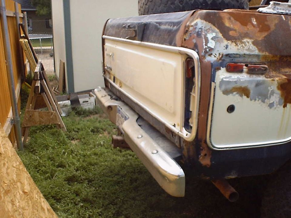 Rusty 1978 Ford Bronco tailgate with a white panel and chrome bumper