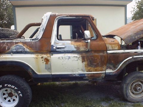 1988 Ford Bronco - This heavily rusted Ford Bronco shows significant body damage and wear.
