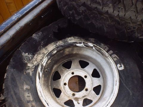 1988 Ford Bronco - A spare tire and wheel are stored inside a vehicle's cargo area.