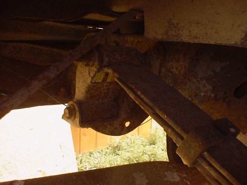 1988 Ford Bronco - Underside view of heavily rusted leaf spring and suspension components.