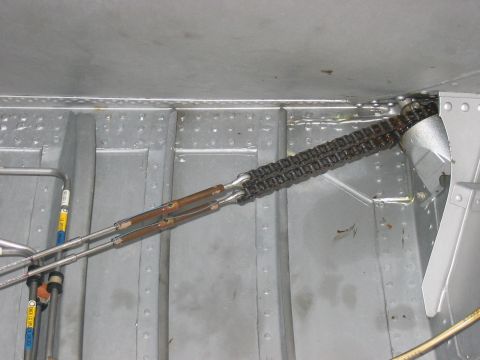 1988 Ford Bronco - Close-up view of the interior of an aircraft fuselage, showing cables and a chain mechanism.