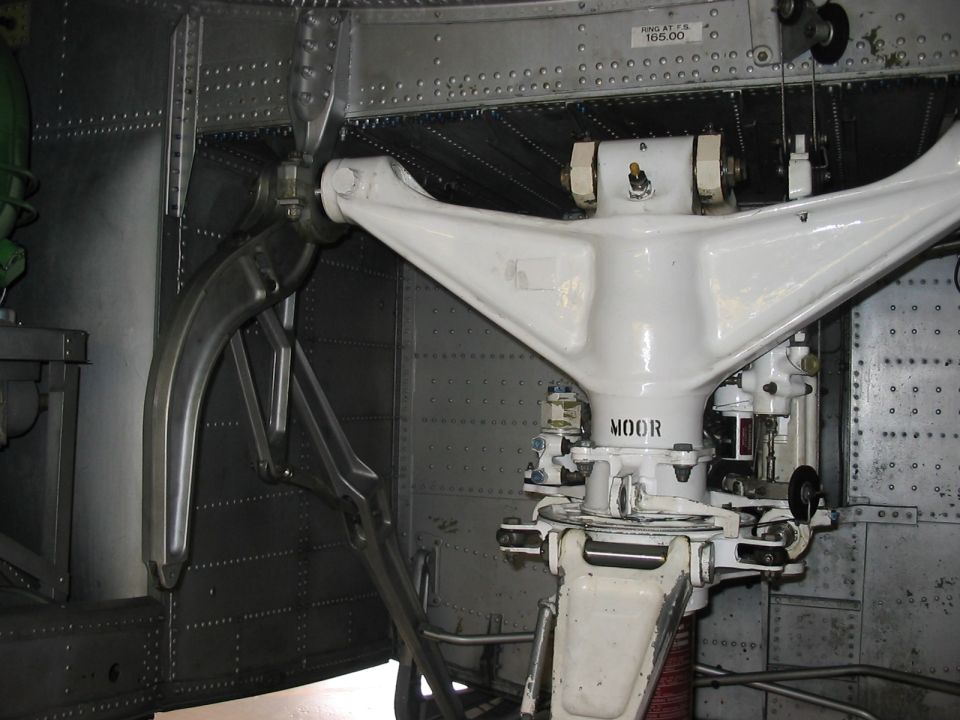 Close-up of a white aircraft landing gear assembly with the word 'MOOR' visible