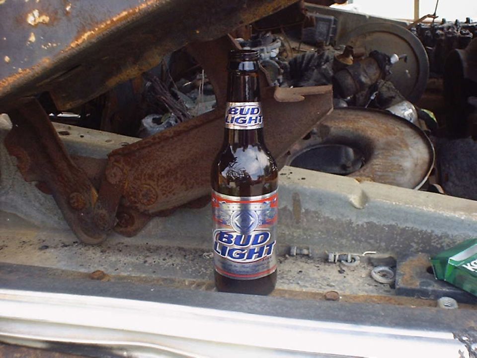Engine bay with a Bud Light bottle and Supermotors.net logo