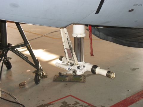 1988 Ford Bronco - Close-up view of aircraft nose landing gear assembly in a hangar.