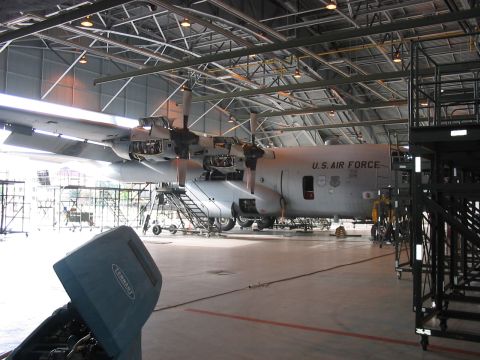 1988 Ford Bronco - A C-130 Hercules aircraft is parked inside a large hangar, undergoing maintenance.