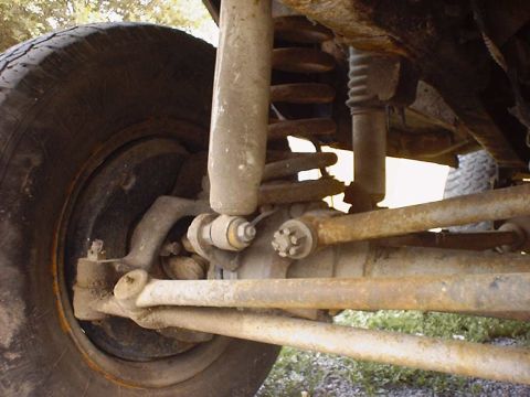 1988 Ford Bronco - This image shows the front suspension and tire of a vehicle, with visible rust on the components.