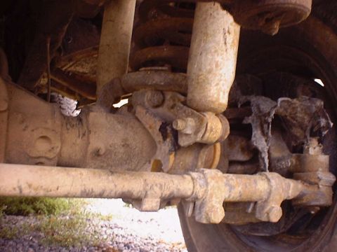 1988 Ford Bronco - The photo shows the underside of a vehicle, focusing on the heavily rusted suspension and steering components.