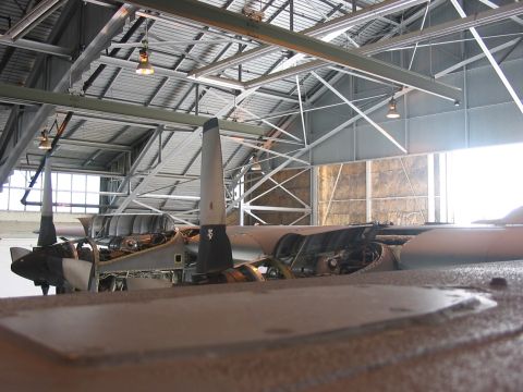 1988 Ford Bronco - An airplane sits in a hangar, its engines and propellers exposed for maintenance or display.