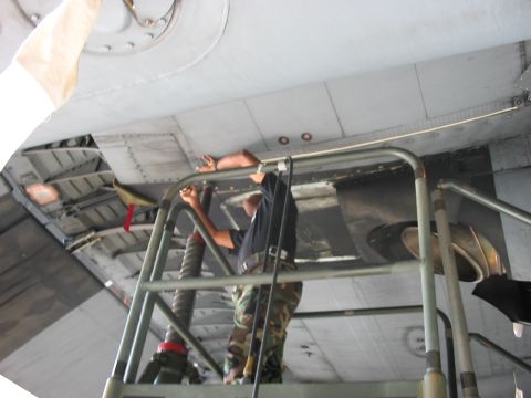 1988 Ford Bronco - Mechanic performs maintenance on the underside of an aircraft.