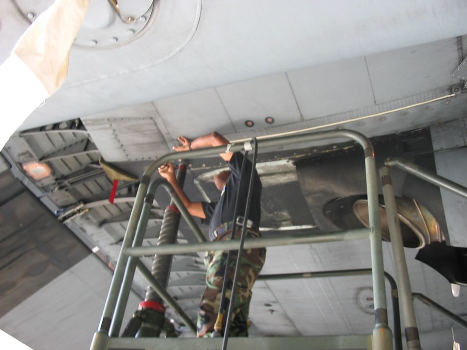 Mechanic working on the underside of an aircraft wing