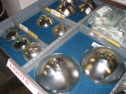 1988 Ford Bronco - Automotive headlights are neatly stored in a compartmentalized tray, ready for installation or sale.
