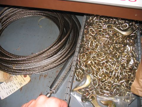 1988 Ford Bronco - A drawer contains a large coil of steel cable and a jumbled pile of golden chains with hooks.