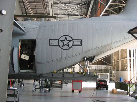 1988 Ford Bronco - A large military cargo aircraft with the US Air Force insignia is undergoing maintenance inside a hangar.