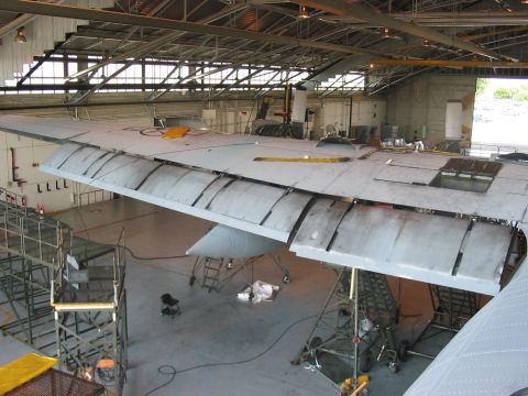 1988 Ford Bronco - Airplane wing maintenance in progress within a large hangar structure.