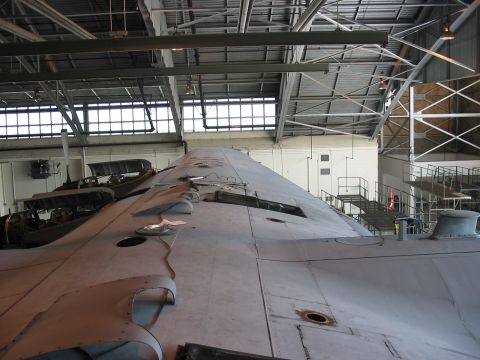 1988 Ford Bronco - An aircraft wing is shown in a hangar, with other parts of aircraft visible in the background.