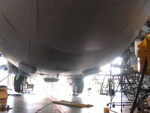 1988 Ford Bronco - View of the underside of an aircraft, showing landing gear and structural elements within a hangar.