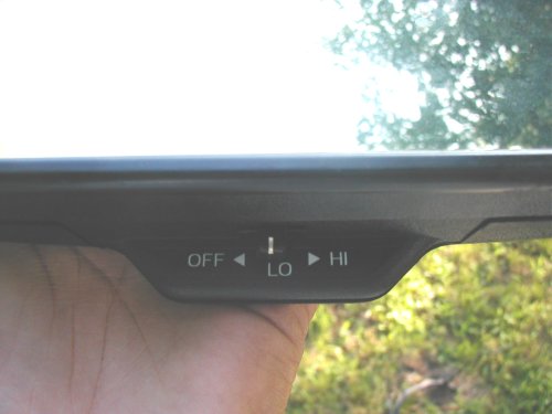 Black switch labeled OFF, LO, HI held in hand outdoors