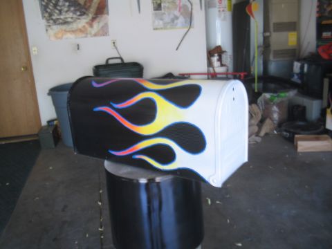 1981 Ford Bronco - Mailbox with custom flame paint job sits on a stand in a garage.