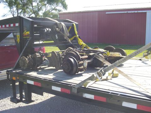 1992 Ford Bronco - Axles and suspension parts are secured to a trailer for transport.