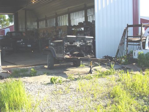 1992 Ford Bronco - A disassembled Jeep CJ-7 chassis is visible in a barn, with another vehicle in the background.