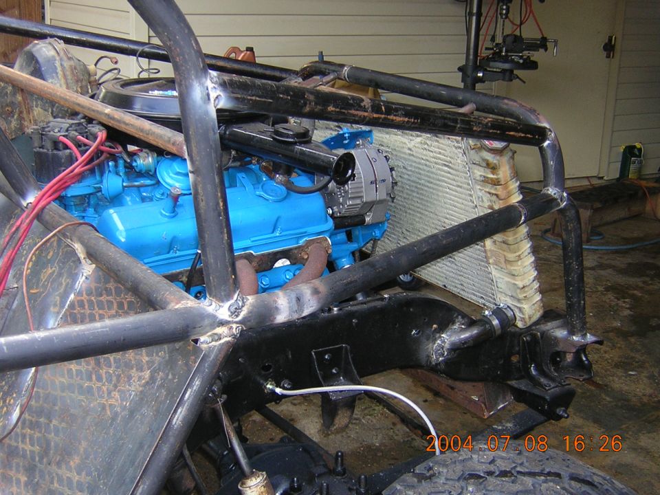 Custom off-road vehicle chassis with blue engine, radiator, and roll cage. Visible date stamp 2004