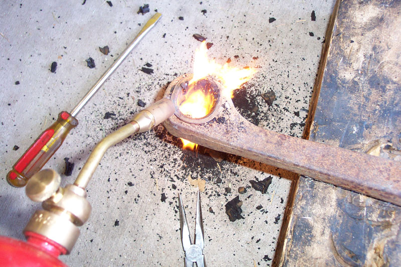 Step 3--Use one of those $10 torches that you find at the parts stores to burn out the rest of the bushing.  Burn it some, the use pliers and a scraper to get the rubber out.  Repeat until there's almost nothing left.
