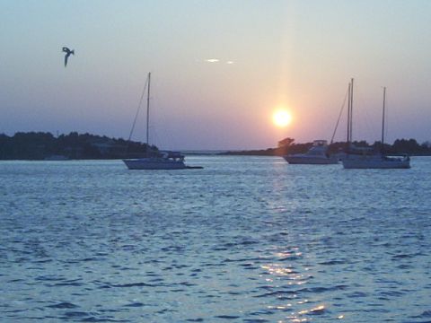 1995 Ford Bronco - Several boats are on the water as the sun sets, casting a warm glow on the scene.