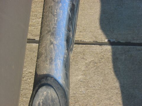 1988 Ford Bronco - A close-up of a chrome step bar on a vehicle, showing dirt and reflections.