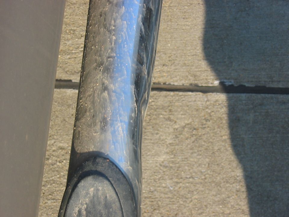 Chrome step bar on a gray vehicle, close-up view