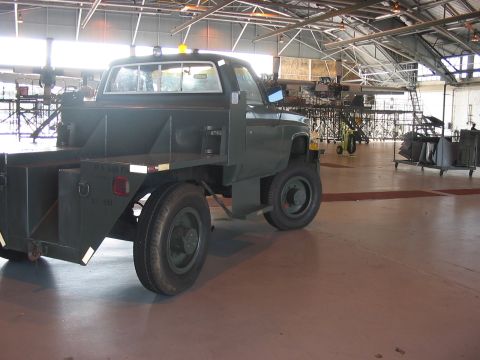 1988 Ford Bronco - A utilitarian truck with a distinctive flatbed and storage compartments sits in a workshop environment.