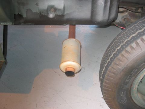 1988 Ford Bronco - Close-up view of an exhaust muffler and tire, likely from a vehicle's undercarriage.