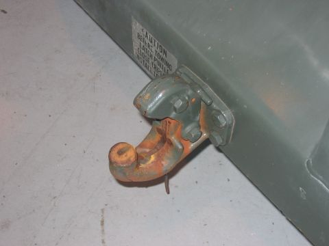 1988 Ford Bronco - A close-up view of a rusty tow hitch with a caution label indicating towing instructions.