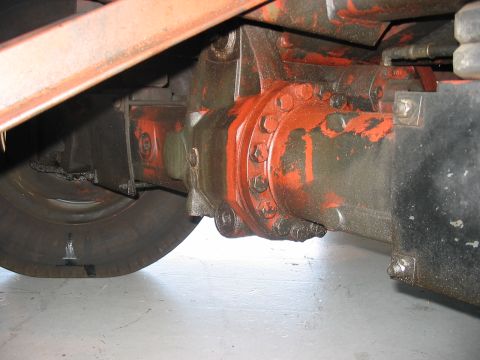 1988 Ford Bronco - Detail of a large axle and wheel, likely from industrial equipment, showing wear and paint.