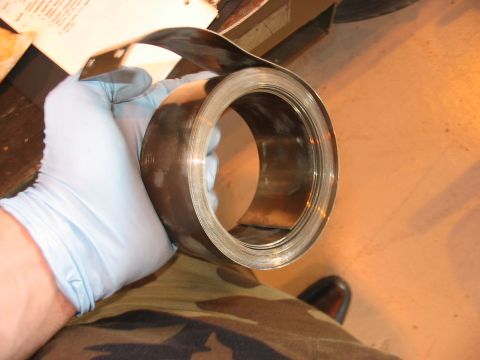 1988 Ford Bronco - A gloved hand holds a large metal coil, with a SuperMotors.net watermark visible at the bottom right.
