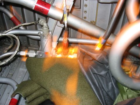 1988 Ford Bronco - Close-up view of the complex interior of an aircraft, showing various pipes, wiring, and a green blanket.