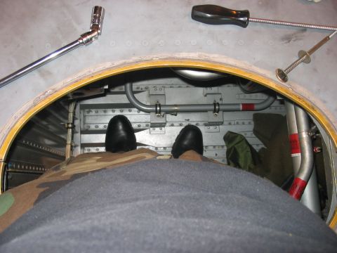 1988 Ford Bronco - Tools are laid out near an open hatch, with a person's feet visible inside the aircraft's interior.